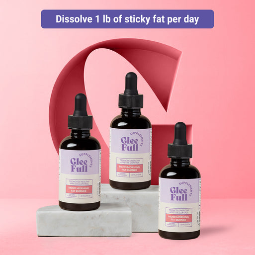 Product display for GleeFull Meno Morning Fat Burner dietary supplement. A purple banner across the top reads: 'Dissolve 1 lb of sticky fat per day'. Three amber glass dropper bottles with purple and cream labels are arranged on grey marble blocks against a pink background with a large coral letter G graphic. Each label reads 'GleeFull Supplements, Promotes Healthy Appetite Control, Meno Morning Fat Burner, Dietary Supplement, 60 ML/2 FL OZ'.