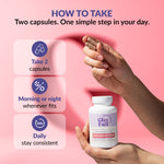 Supplement bottle with instructions on how to take it, 2 capsules a day, morning or night and highlighting the importance of consistency,  held by a hand against a pink background.