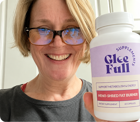 Smiling woman with glasses holding a bottle of Gleefull Meno-Shred Fat Burner