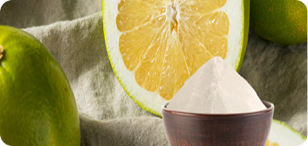Lemon, lime, and a bowl of white powder on a textured surface
