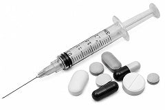 Medical syringe with needles and various pills on a white background